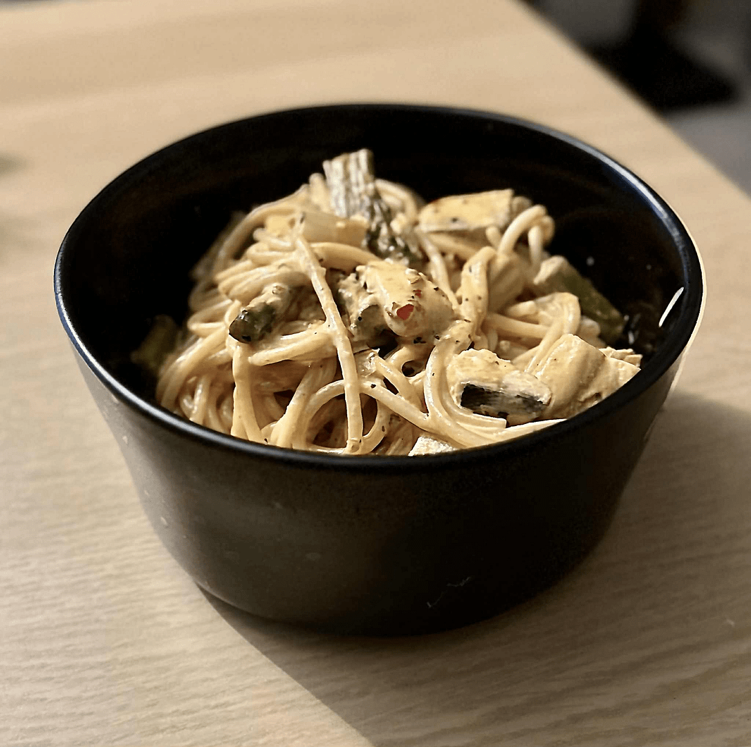 delicious salmon pasta in black bowl